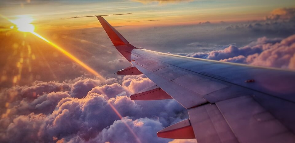 雲の上を飛ぶ飛行機の写真